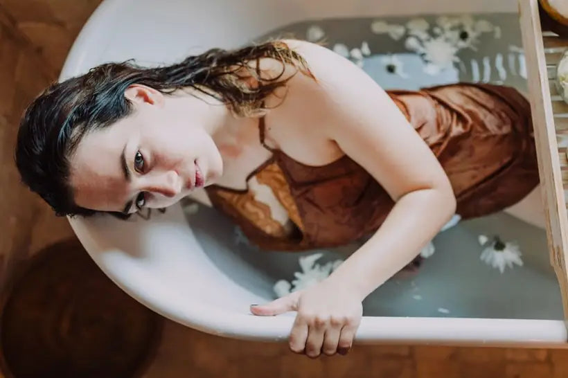Woman relaxing in a bath, warm editorial wellness photography